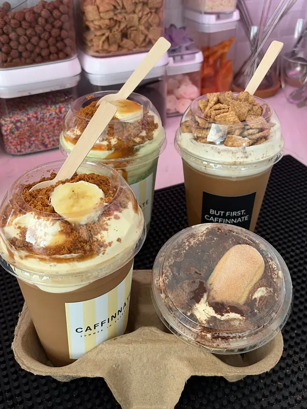 Banana crème pie latte topped with vanilla custard, biscoff crumble and a banana slice