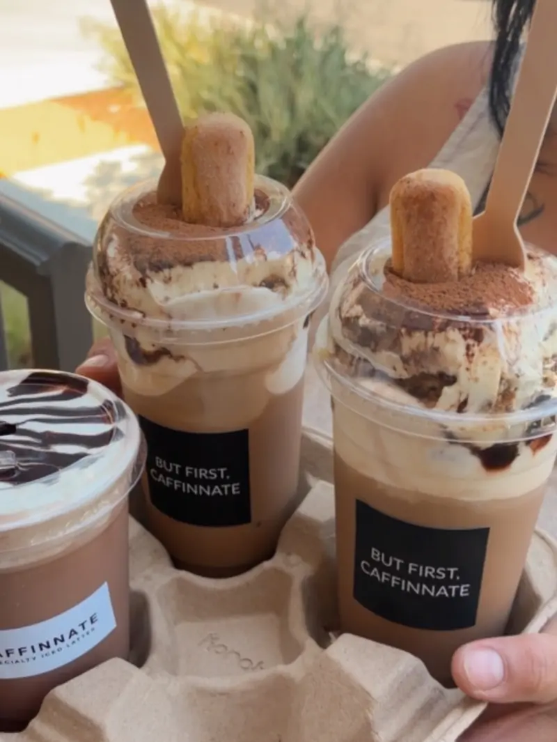 Close view of tiramisu lattes with cream, cocoa and chocolate drizzle
